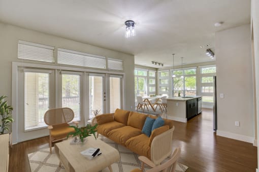 a living room with a couch and a table and a kitchen