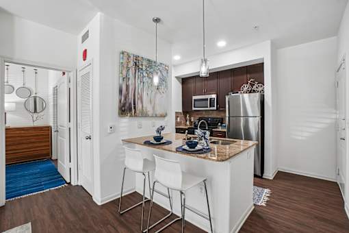A kitchen with white cabinets and a wooden island.