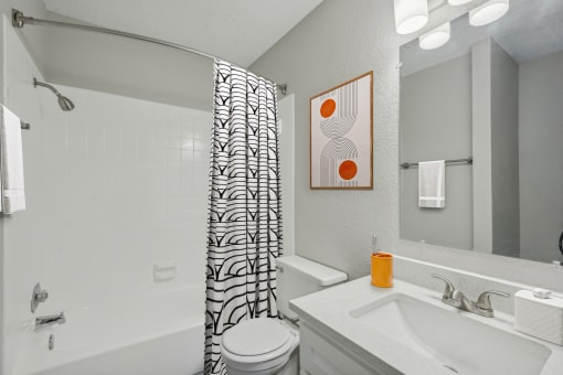 a bathroom with a shower curtain and a sink and a toilet