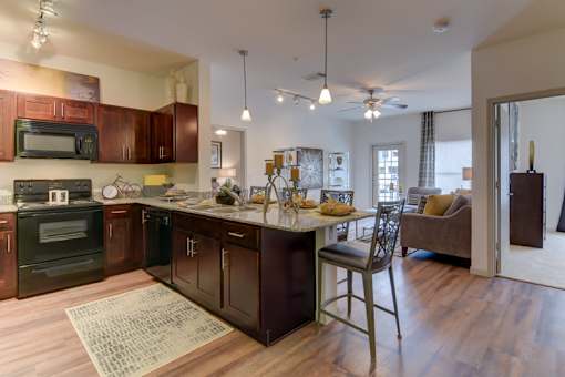 A kitchen with dark wood cabinets and a large island.