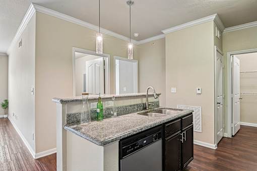 A kitchen with a granite countertop and a green bottle on it.