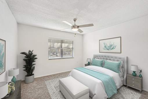 A bedroom with a large bed and a ceiling fan.