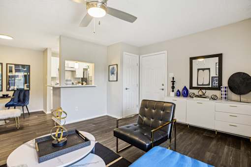 A living room with a black leather chair and a white coffee table.