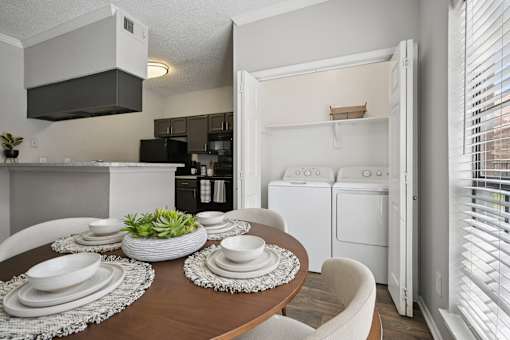 A modern kitchen with a dining table set for two.