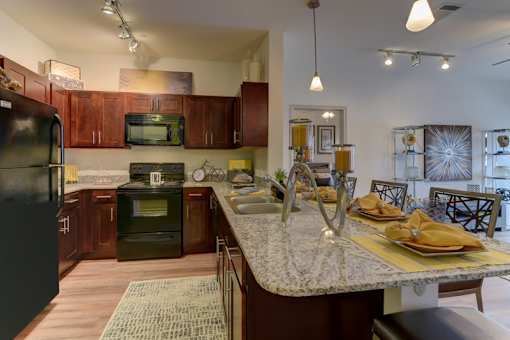 A kitchen with brown cabinets and a granite countertop.