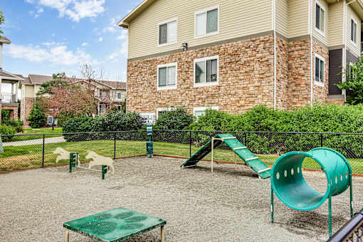 A playground with a green slide and a green table in the middle of the playground.