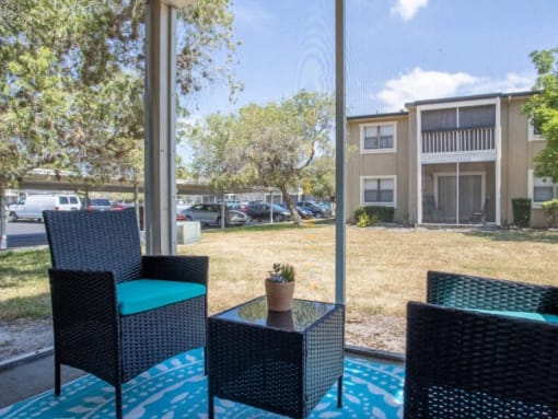a patio with chairs and a table in front of a building