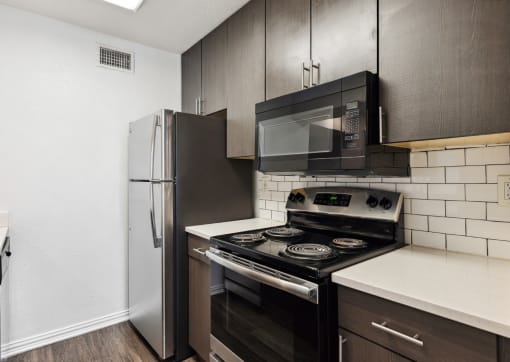 an empty kitchen with a stove and a refrigerator
