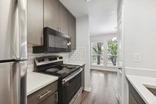 an empty kitchen with a stove and a microwave
