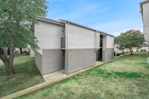 a modern house with a lawn and trees