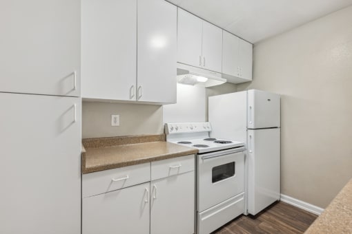 a white kitchen with white appliances and white cabinets