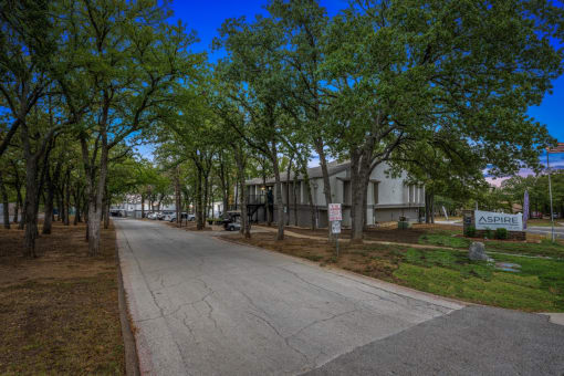 a street with a building and trees on both sides of it