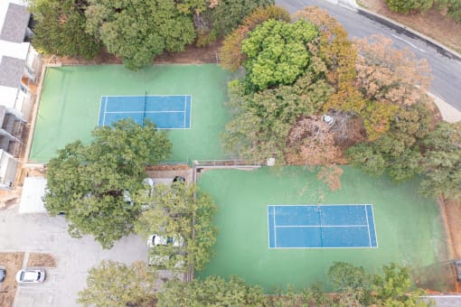 a birds eye view of a tennis court with trees