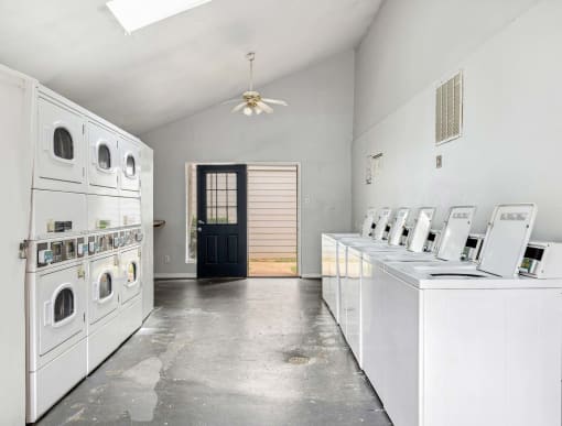 a white laundry room with washers and dryers