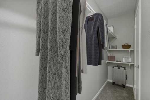 a small room with a wardrobe and a radiator and clothes hanging on the wall