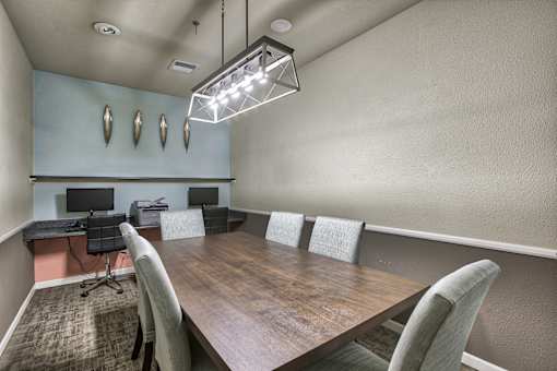 A conference room with a long table and chairs.