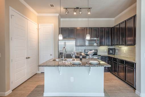 A kitchen with a granite countertop and a white island.