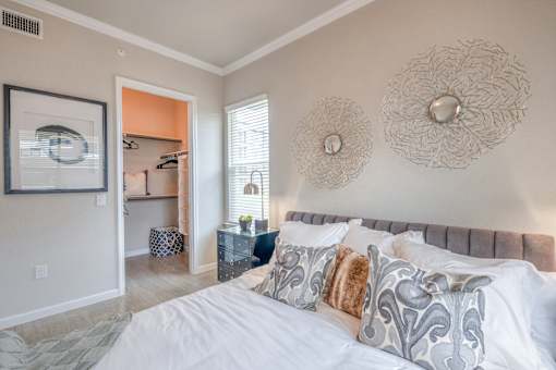 A bedroom with a large bed and a painting on the wall.