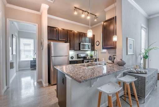 A kitchen with a granite countertop and a refrigerator.