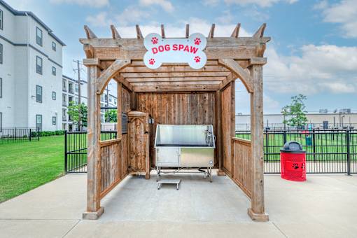 A dog spa sign is above a table and chairs set up on a patio.