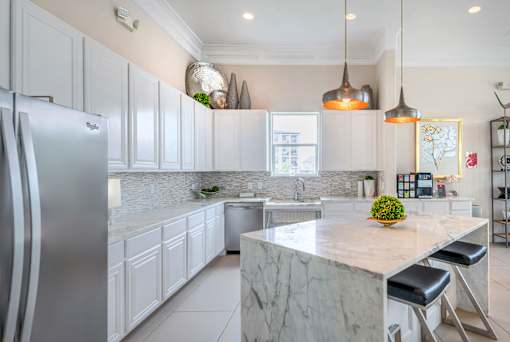 A kitchen with a marble countertop and stainless steel appliances.