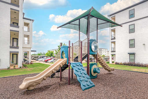 A playground with a slide and a climbing frame.