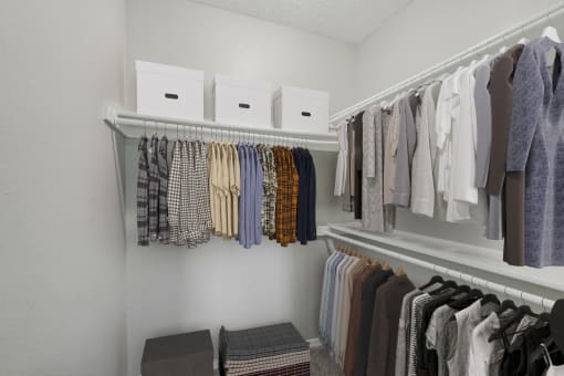 a walk in closet with racks of clothes and boxes on the shelves