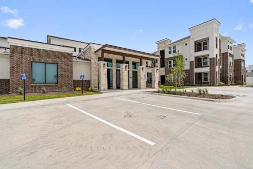A parking lot in front of a building with a clear blue sky.