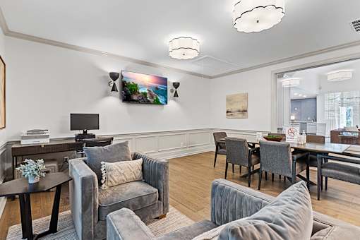 a living room with couches and chairs and a table and a tv