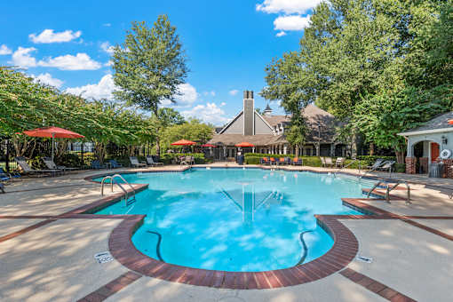 a swimming pool with trees and a house in the background