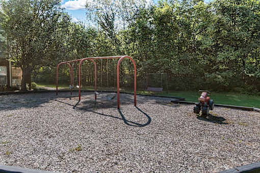 a playground with a swing set and a fire hydrant