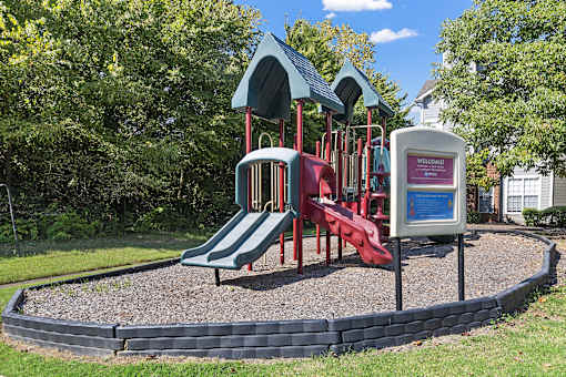 a playground with a red slide and a blue and red