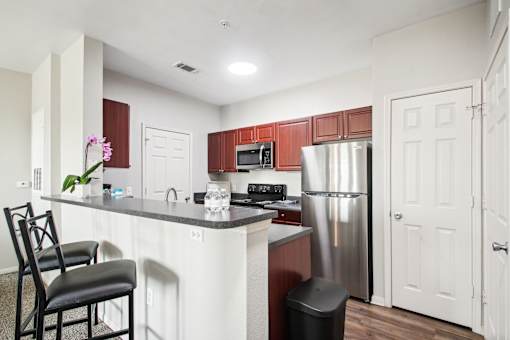 a kitchen with a island and a stainless steel refrigerator