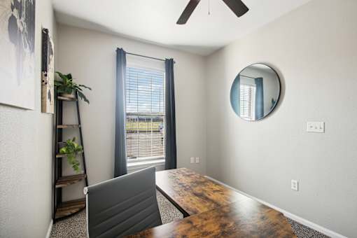 a dining room with a large window and a desk with a laptop