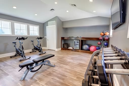 A home gym with a bench, weights, and exercise equipment.