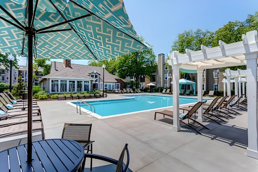 A pool area with a white canopy and a table and chairs.