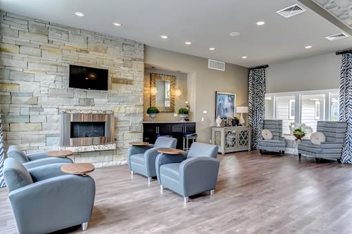 A living room with a stone fireplace and grey couches.
