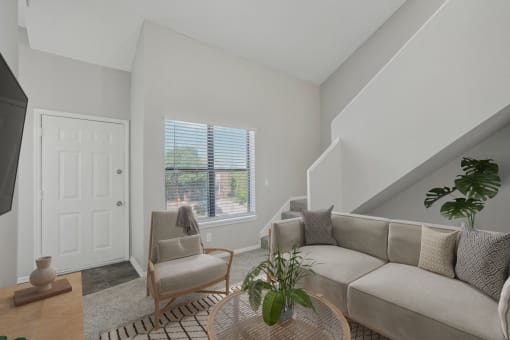 a living room with a couch and a chair and a window