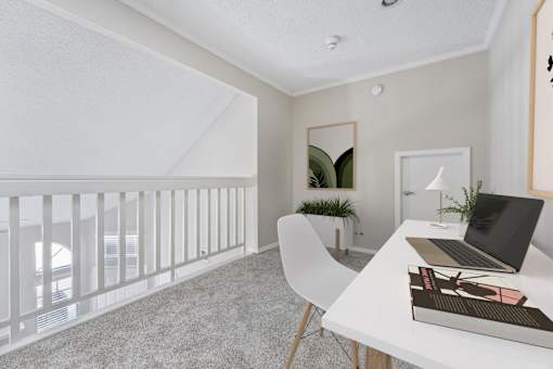 a home office with a white desk and a laptop on a desk