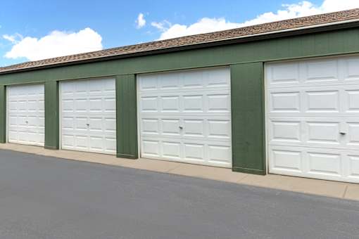 Three garage doors are closed and lined up on a building.