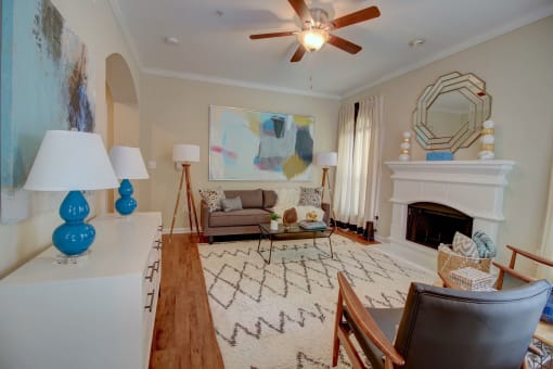 a living room filled with furniture and a ceiling fan
