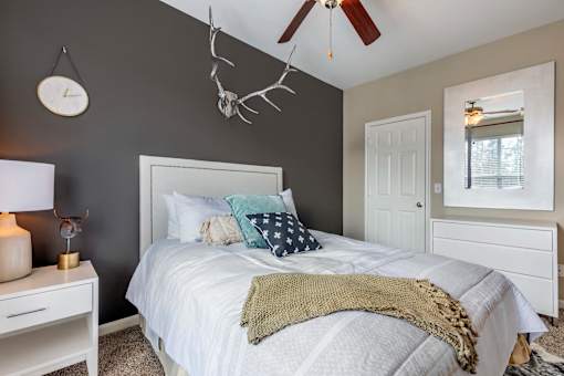 A bedroom with a white bed and a white nightstand.