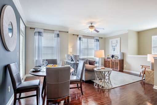A dining room with a table set for two and a ceiling fan.