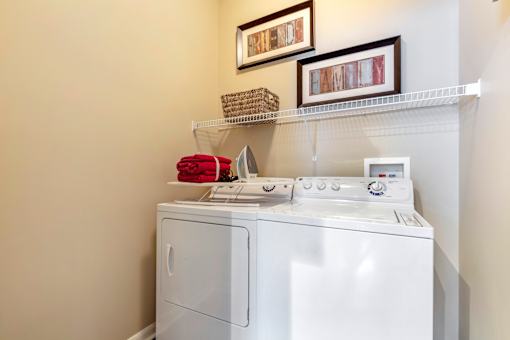 A white washing machine with a red towel on top of it.