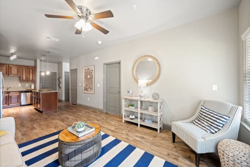 a living room with a ceiling fan and a blue and white rug