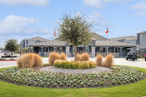 a circular flower garden in front of a building