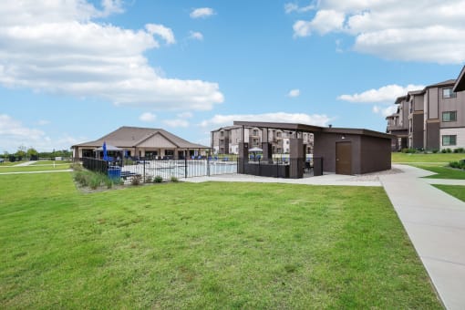 a building with a pool in front of a grassy field