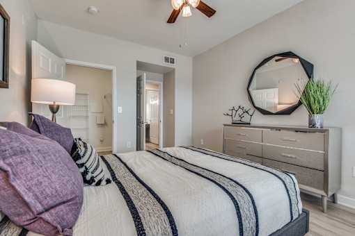 A bedroom with a bed, dresser, and mirror.