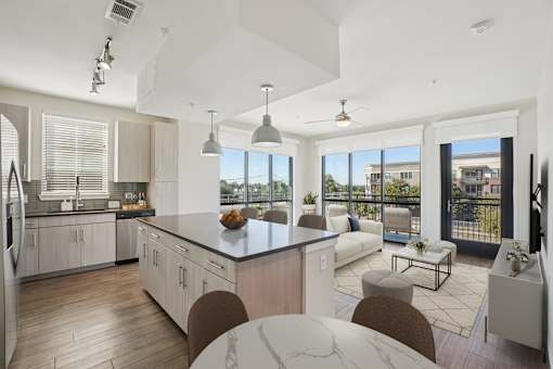 A modern kitchen with a large granite island and a view of Plano, Texas.