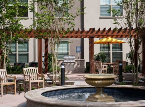 a fountain in a courtyard with tables and chairs